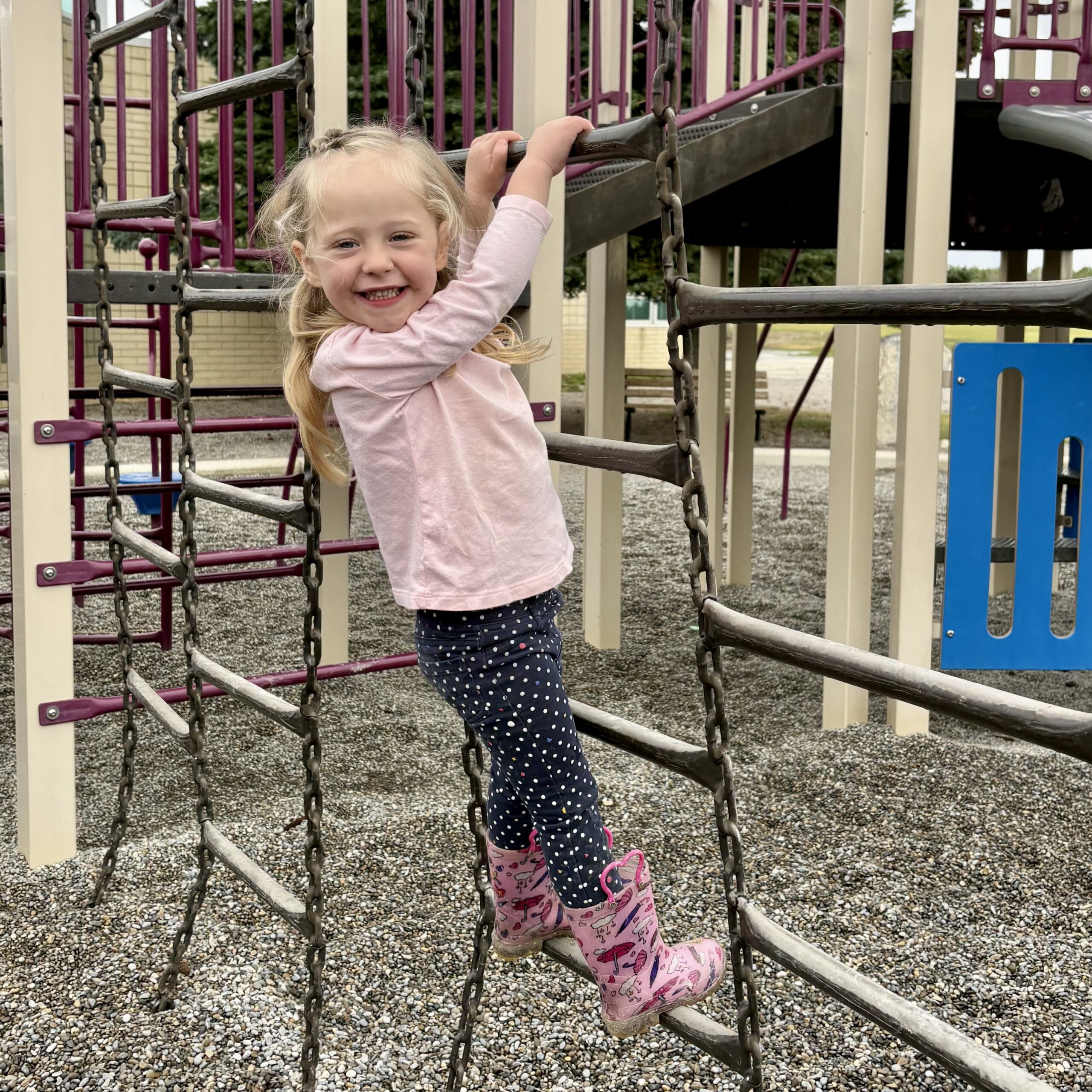 Toddler girl climbing metal ladder