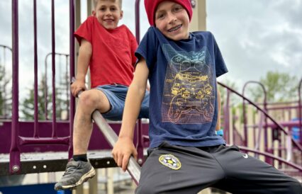Two young boys on slanted parallel bars at a playgroun