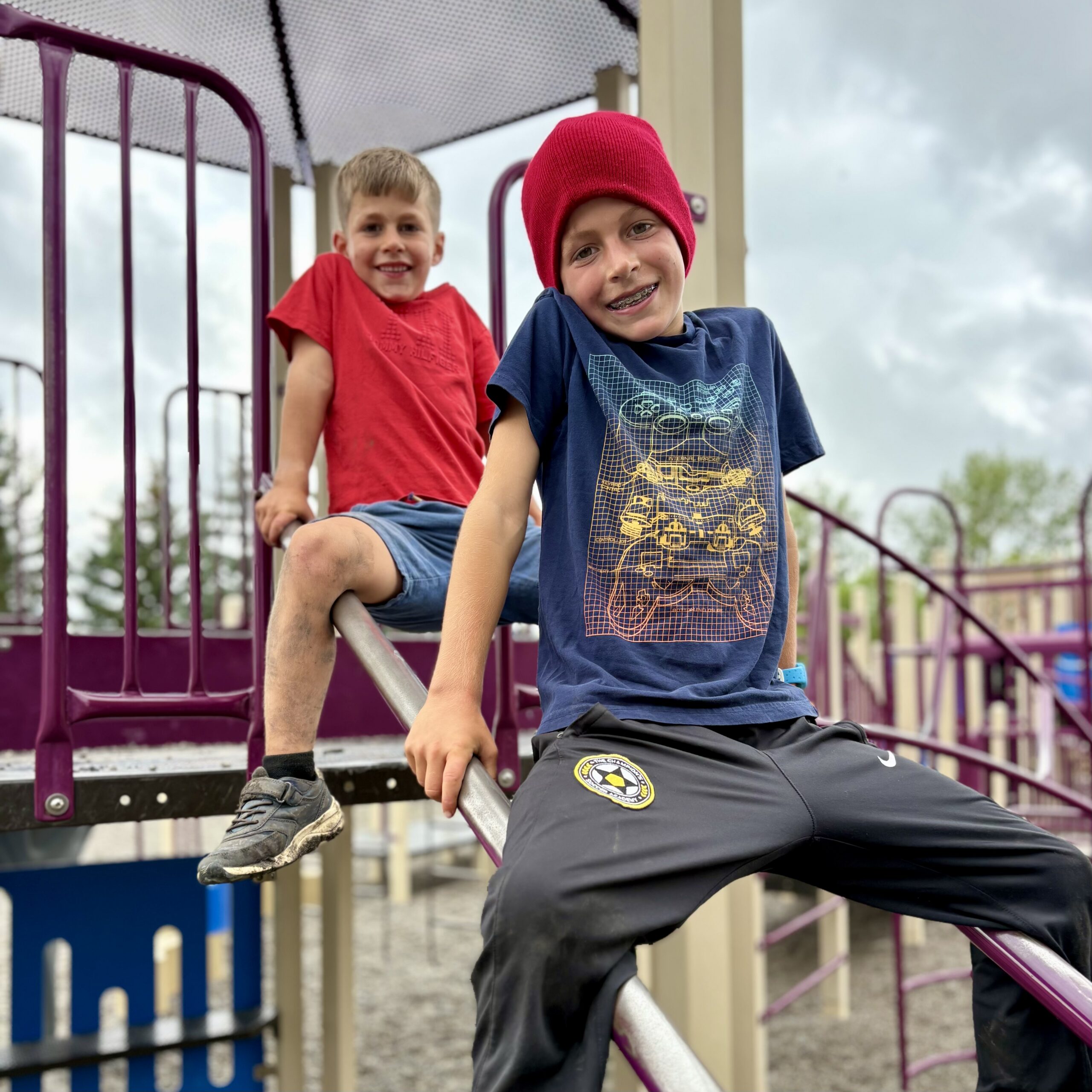 Two young boys on slanted parallel bars at a playgroun