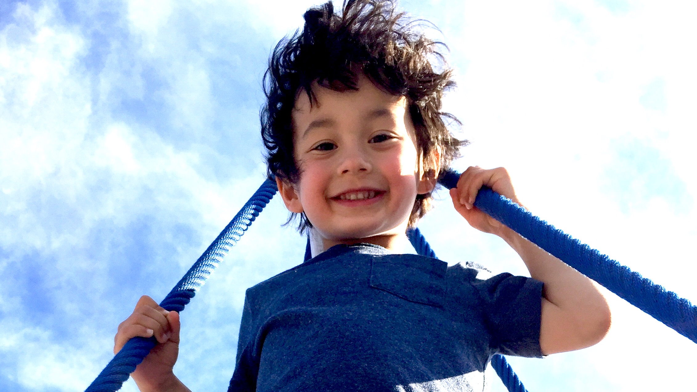 Boy looking down from the rope climbing structure